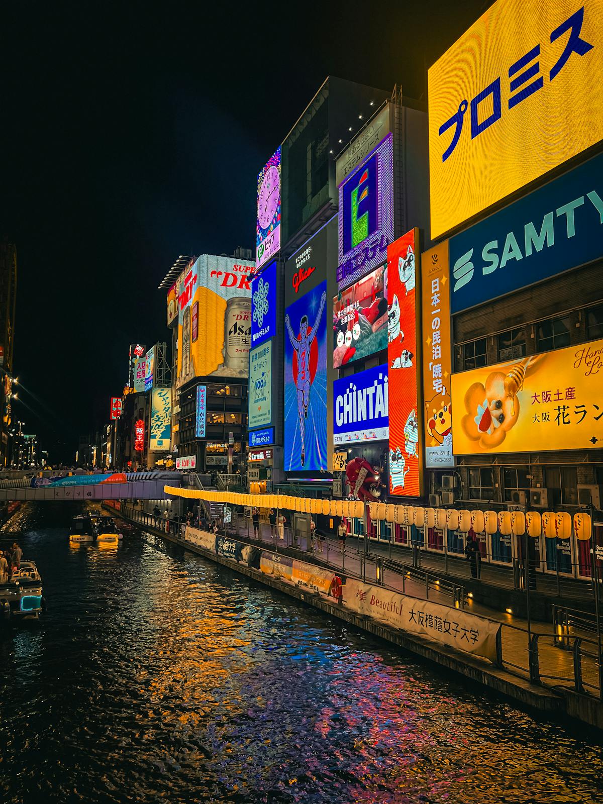 Dotonbori Canal in Osaka neighborhood lit up with neon signs and colorful billboards at night