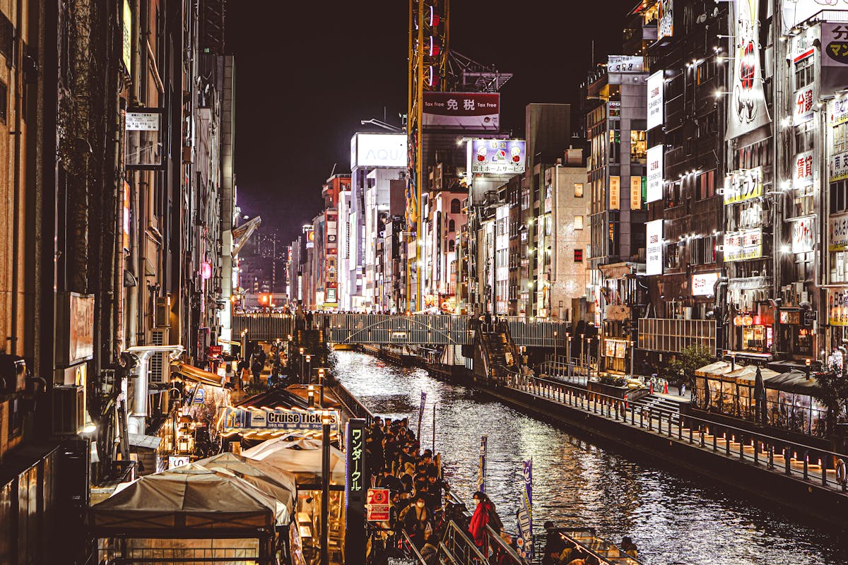 Illuminated Dotonbori Canal in Osaka Japan bustling with nightlife and vibrant neon city lights