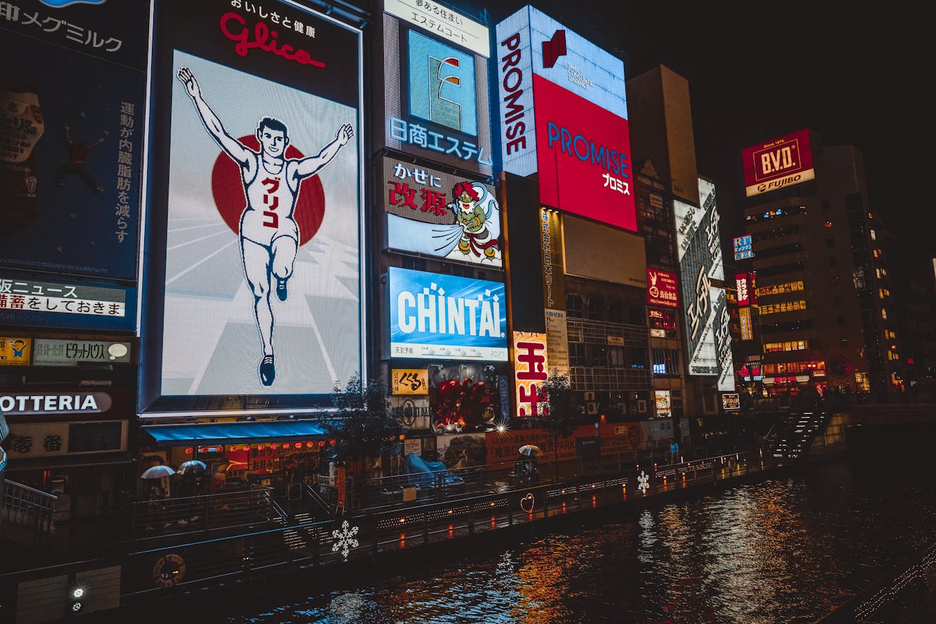 Illuminated signs reflecting on Dotonbori River at night - Dotonbori Osaka guide