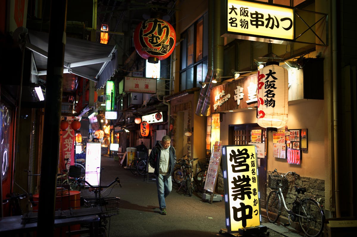 Lantern-lit alley in Osaka neighborhood showcasing traditional Japanese nightlife atmosphere