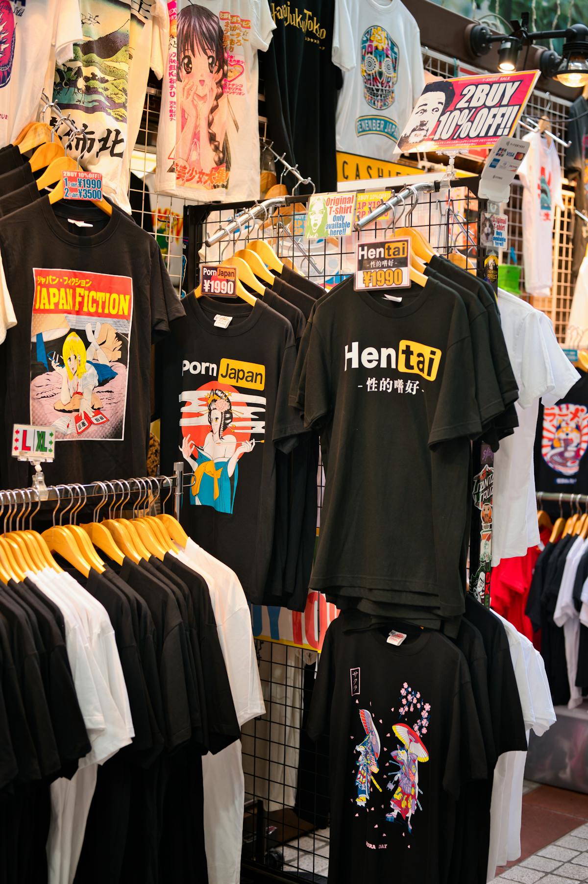Colorful merchandise and graphic t-shirts at a market stall in Osaka shopping district