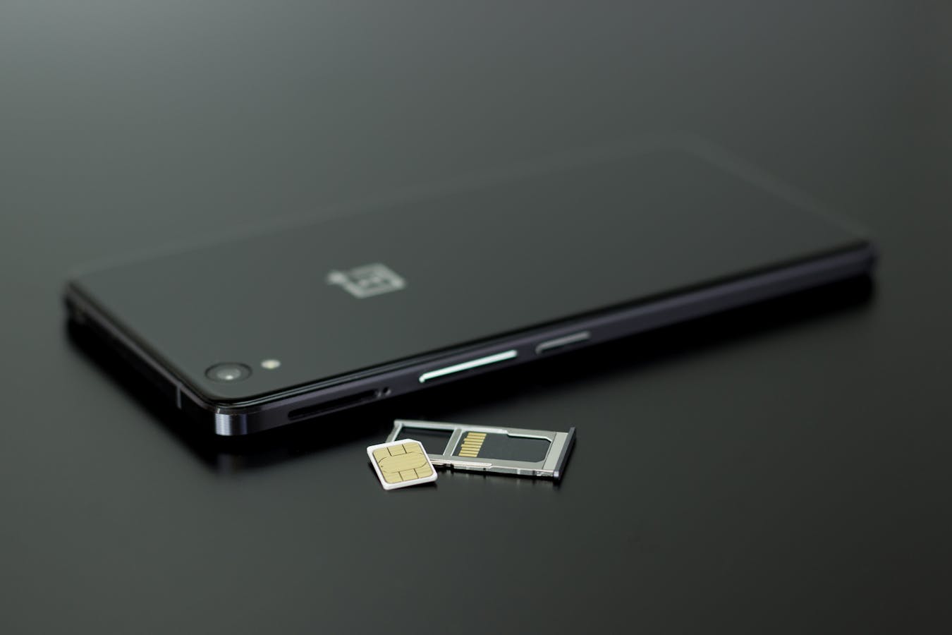 Physical SIM card next to smartphone for Osaka travel