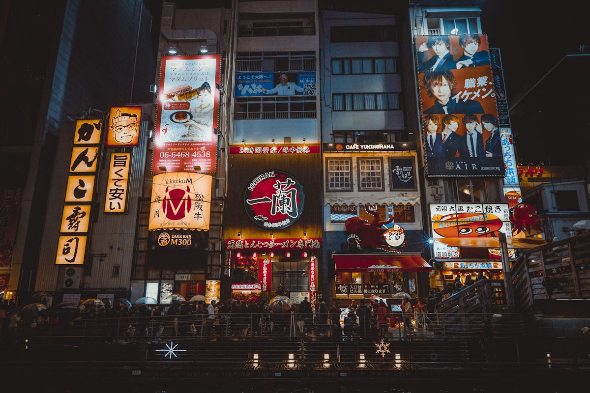 Illuminated neon streets of Osaka bustling with crowds enjoying the vibrant nightlife scene