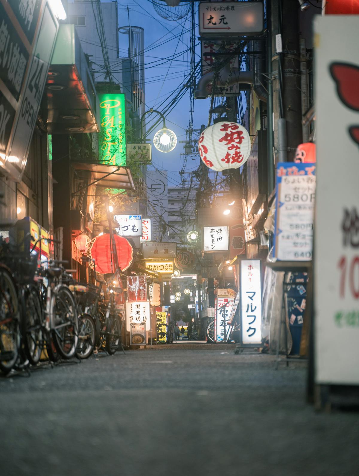Osaka nightlife neon-lit alleyway with glowing signs and urban energy