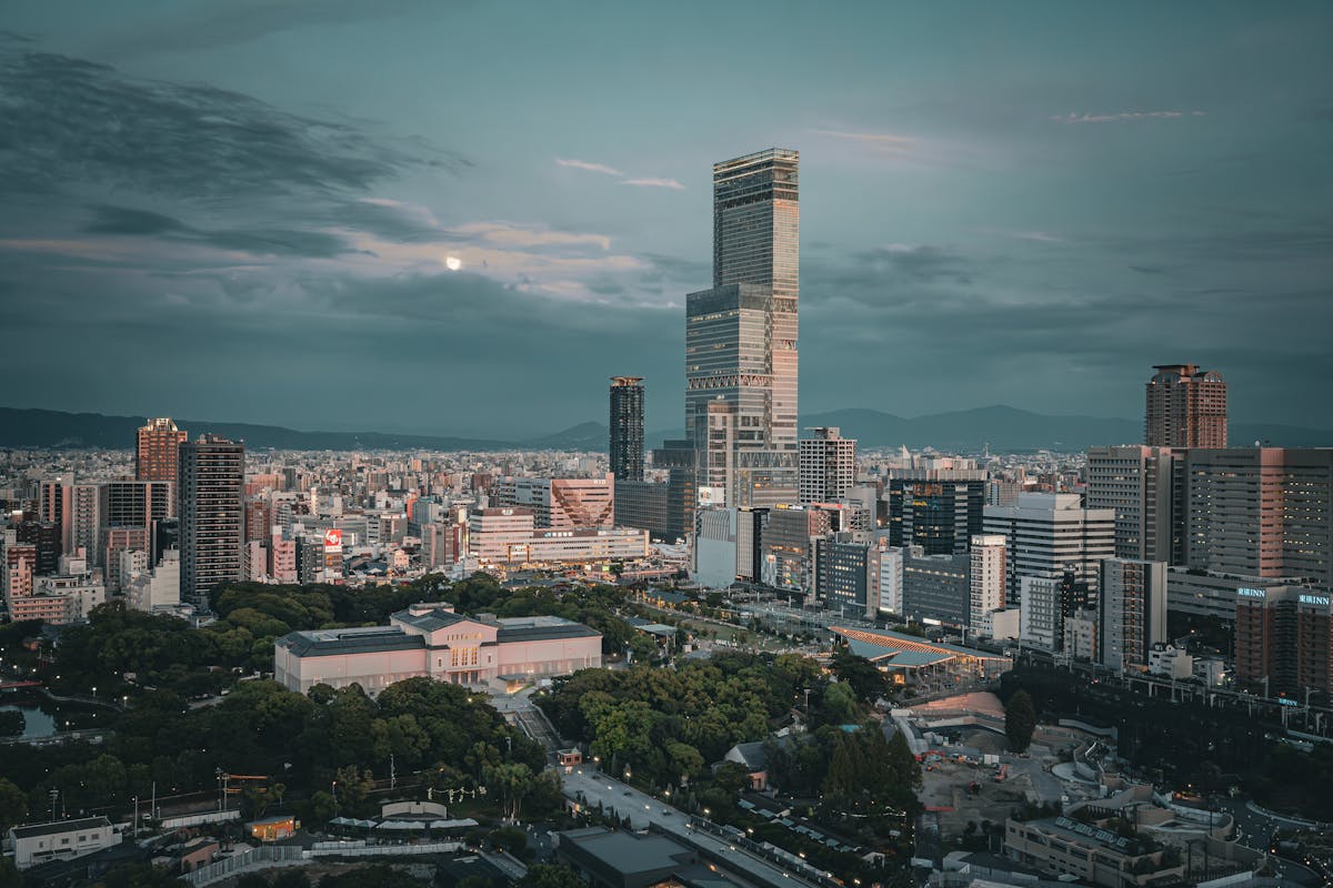 Osaka travel guide - skyline featuring Abeno Harukas at twilight with city lights over the urban landscape