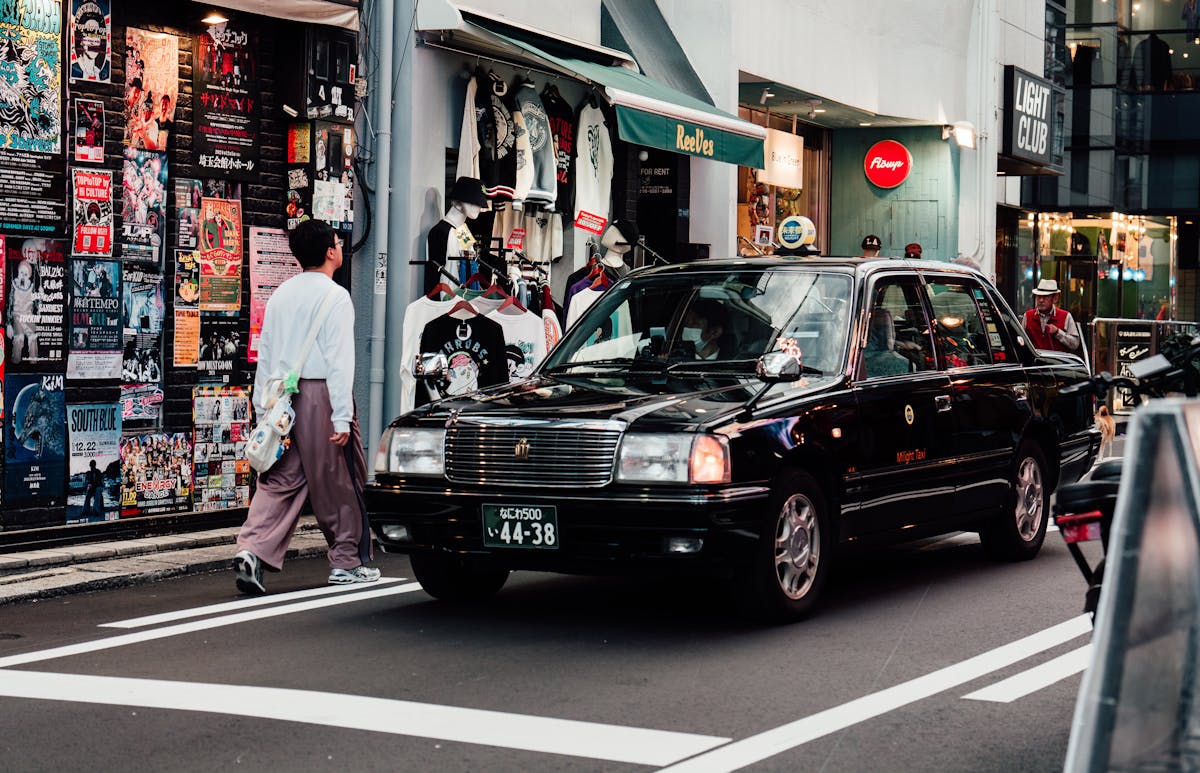 Vibrant street scene in Osaka shopping district with taxis and diverse storefronts