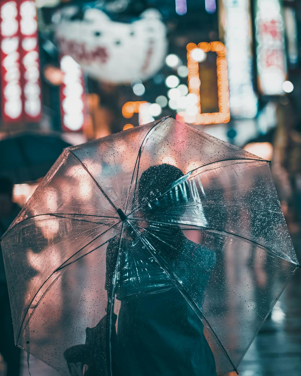Person with umbrella on rainy Osaka street - rainy season weather when visiting Osaka