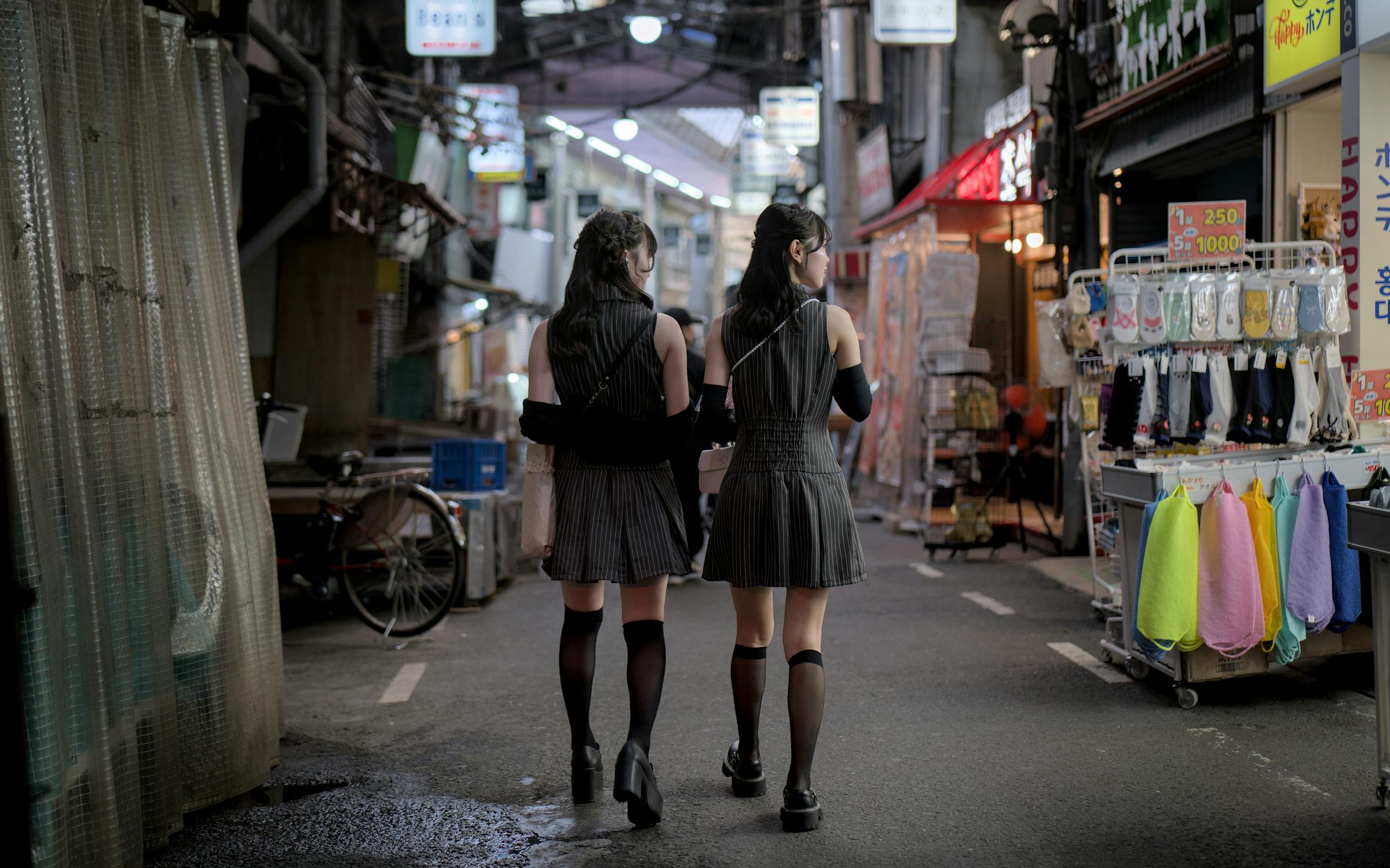 Two young people in street fashion walking through Amerikamura Osaka
