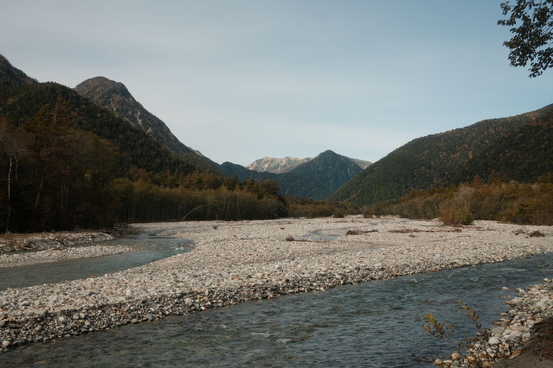 A clear mountain river running through forest, mirroring the Minoo River trail near Osaka
