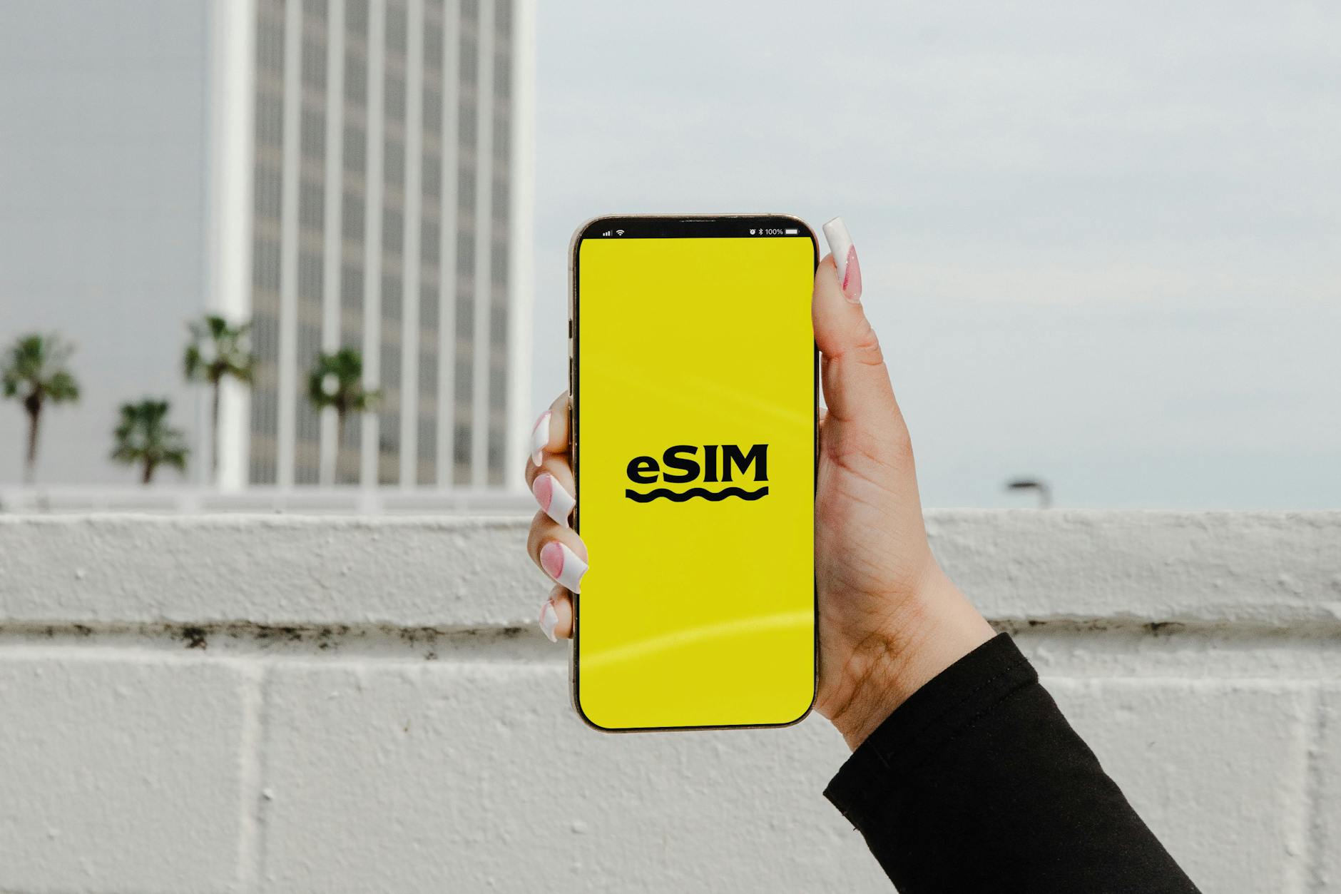 A hand holding a smartphone showing an eSIM, the easiest way to get an Osaka SIM card for mobile data