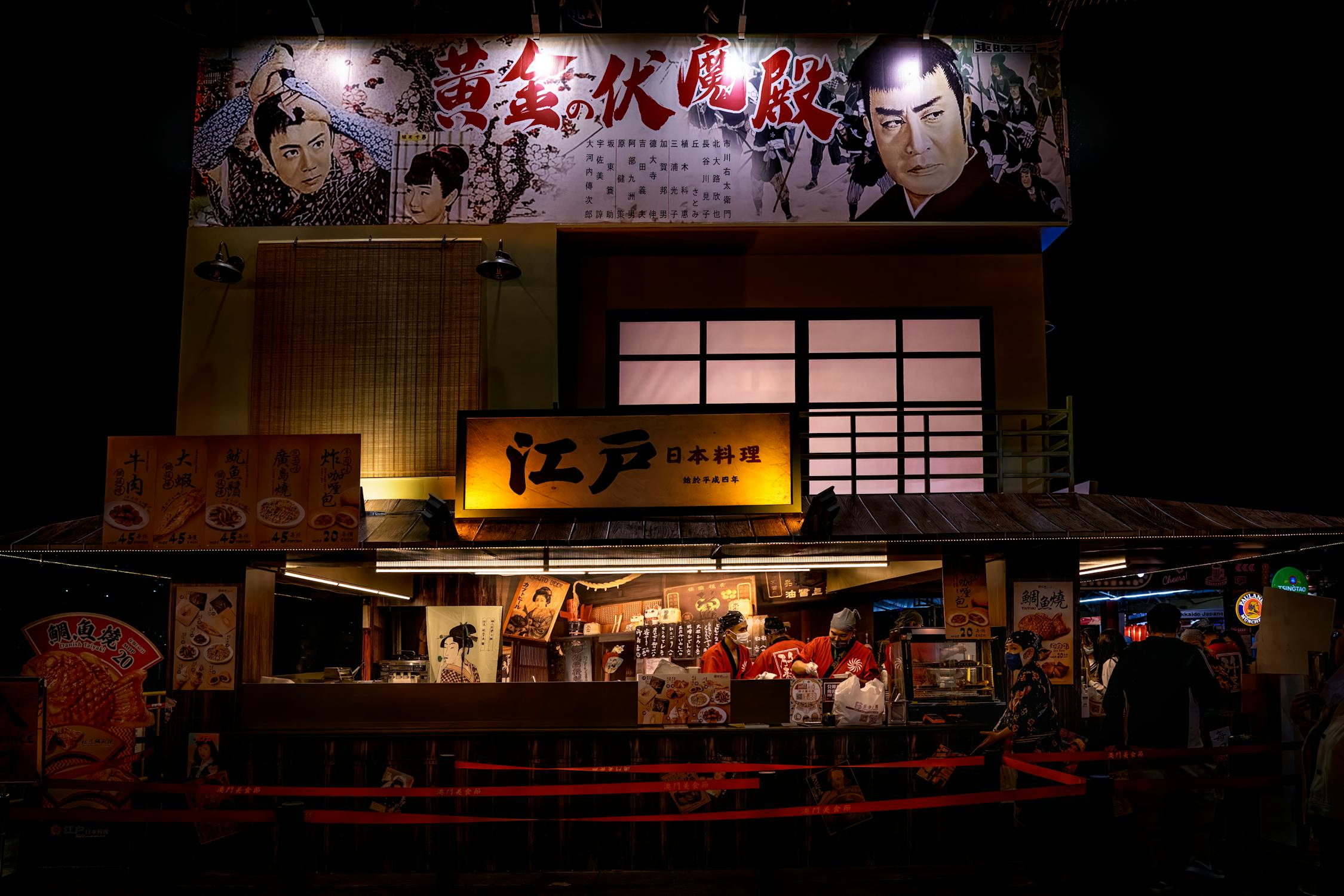 Japanese festival yatai food stall lit up at night with snacks for sale at an Osaka matsuri