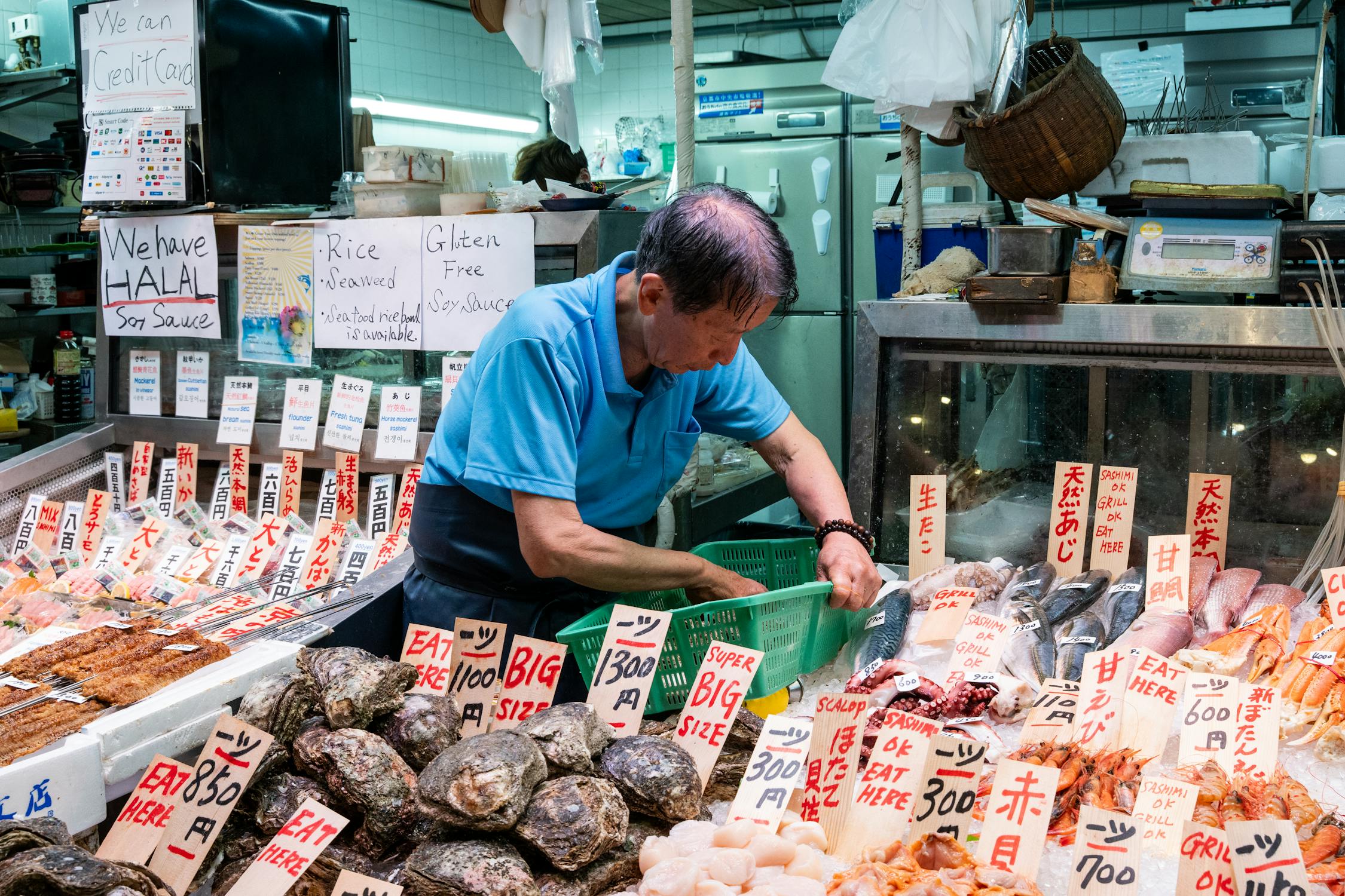 A vendor arranging fresh seafood at Kuromon Market in Osaka