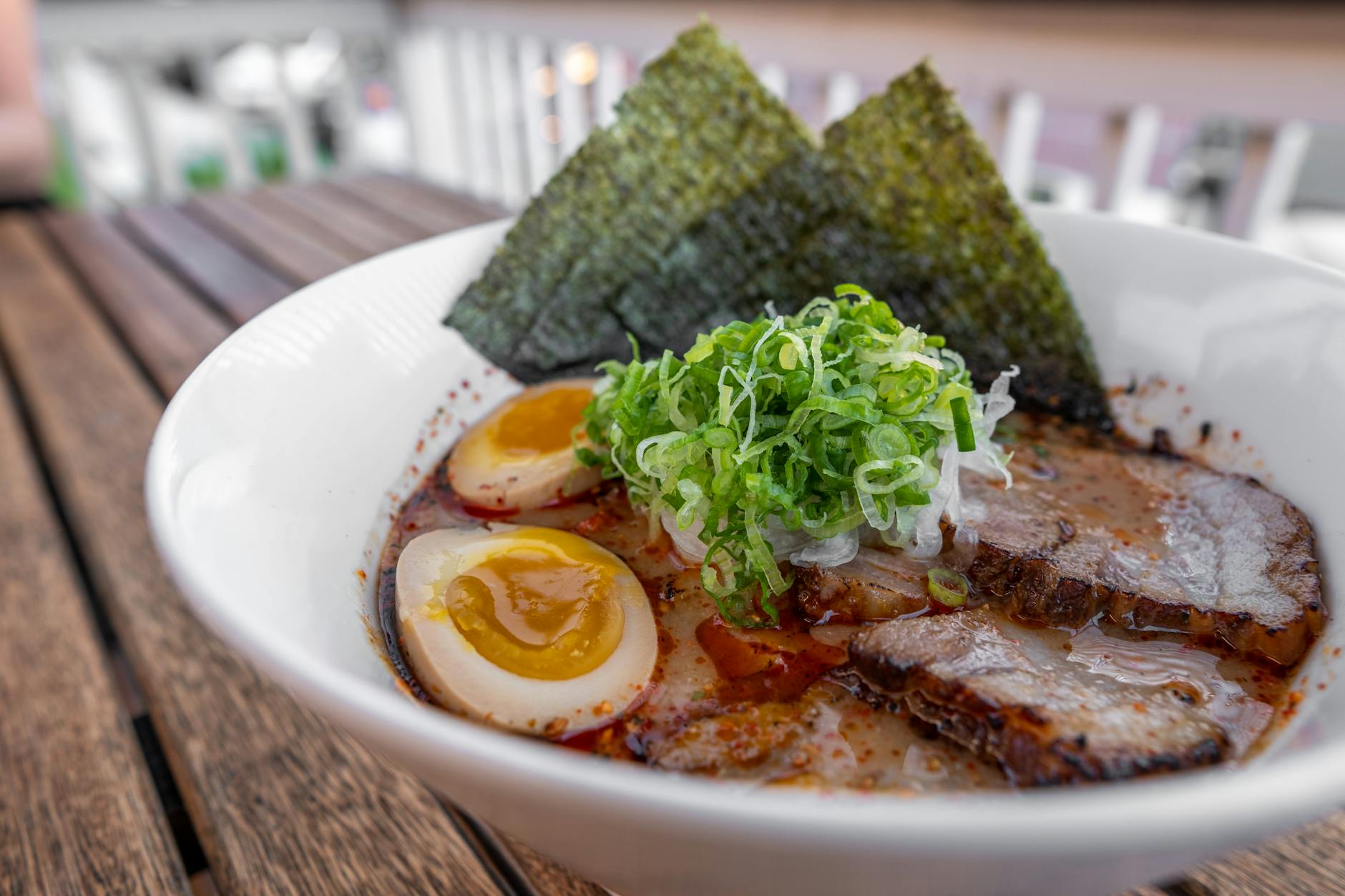 A bowl of ramen with chashu pork, soft egg and green onions in Osaka