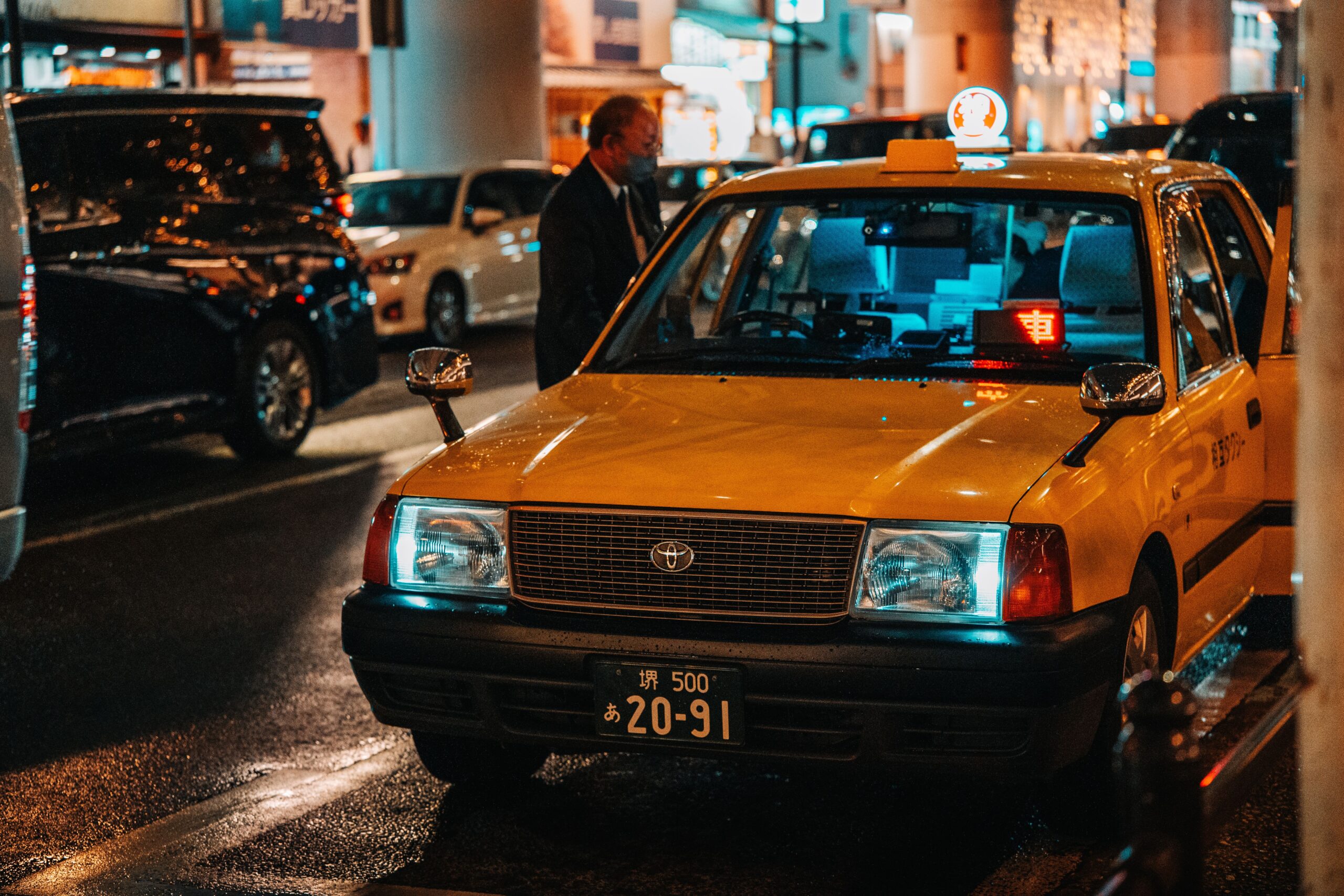 Yellow taxi waiting on a Dotonbori street at night where you can hail a cab in Osaka