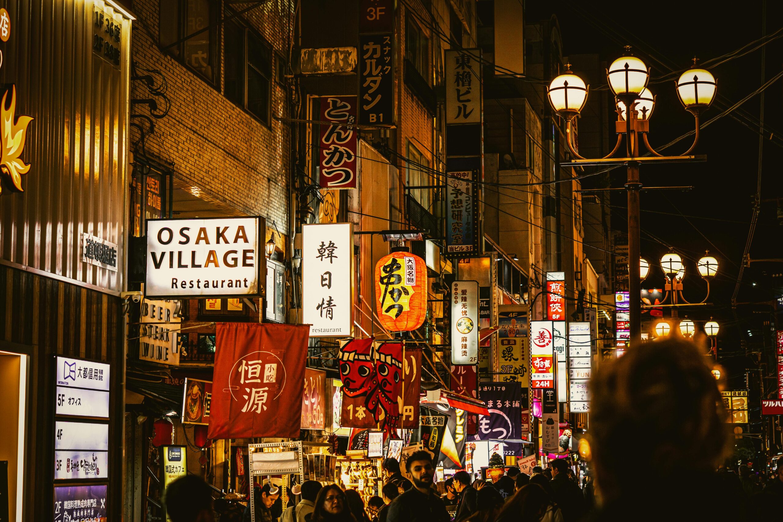 Late-night neon street in Dotonbori where Osaka taxis run after the last train