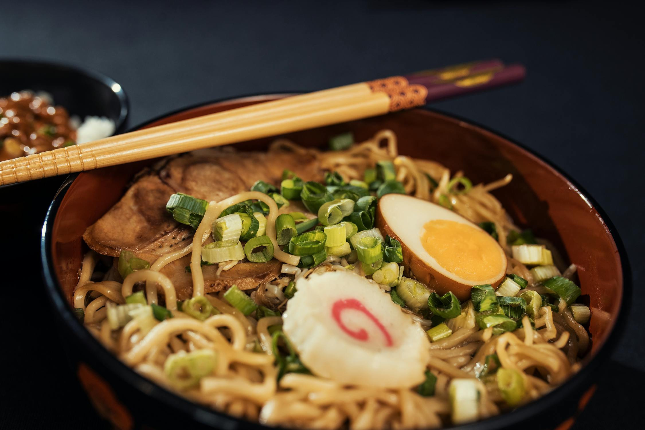 Steaming bowl of Japanese ramen with egg and scallions, ideal rainy day comfort food in Osaka
