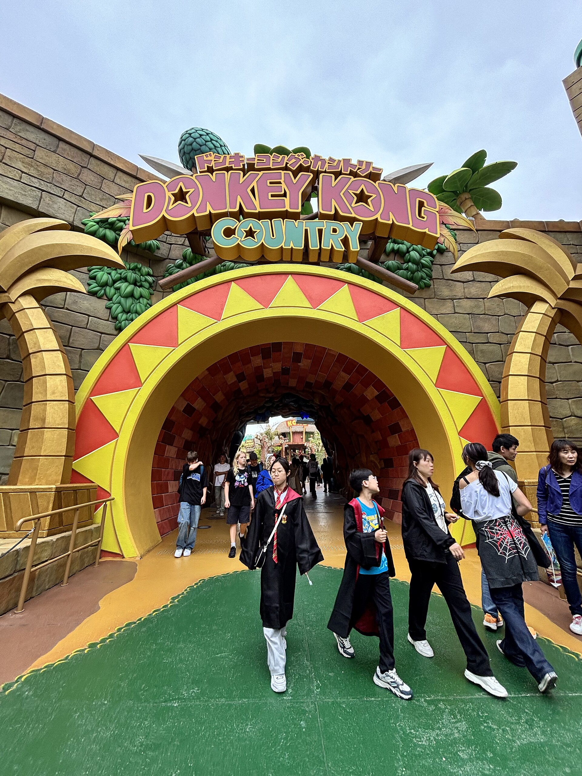 Visitors walk through the colorful arched entrance to Donkey Kong Country at Universal Studios Japan in Osaka.